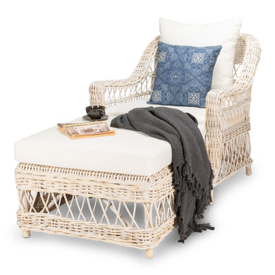Wicker chair and ottoman set with a blue pillow and gray blanket on a white background