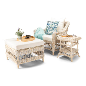 Wicker outdoor furniture set with a chair, ottoman, and side table on a white background